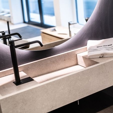 Geometrisches Waschbecken mit einem großen und runden Spiegel